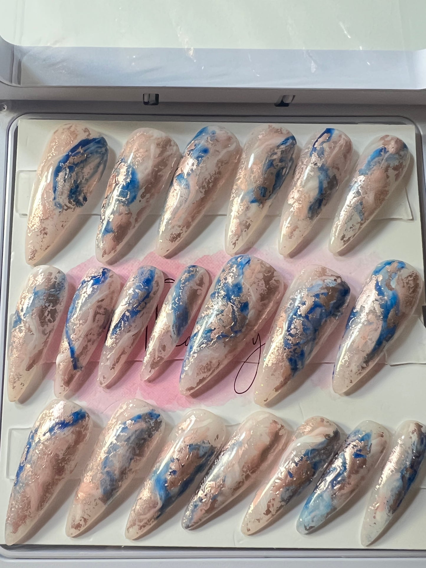 Set of 20 Long Stiletto shaped press-on nails with a layer of acrylic with hard gel over that. Gel polish; rose, white and blue marbled and hard gel top coat.