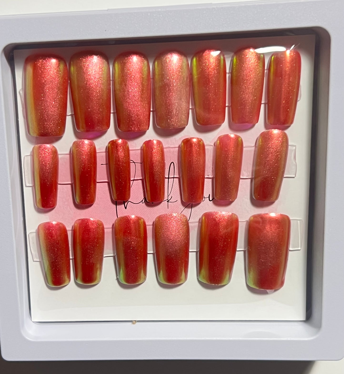 Set of 20 Medium length square press-on nails with a dark red gel polish and aurora chrome over the whole nail. No stain top coat