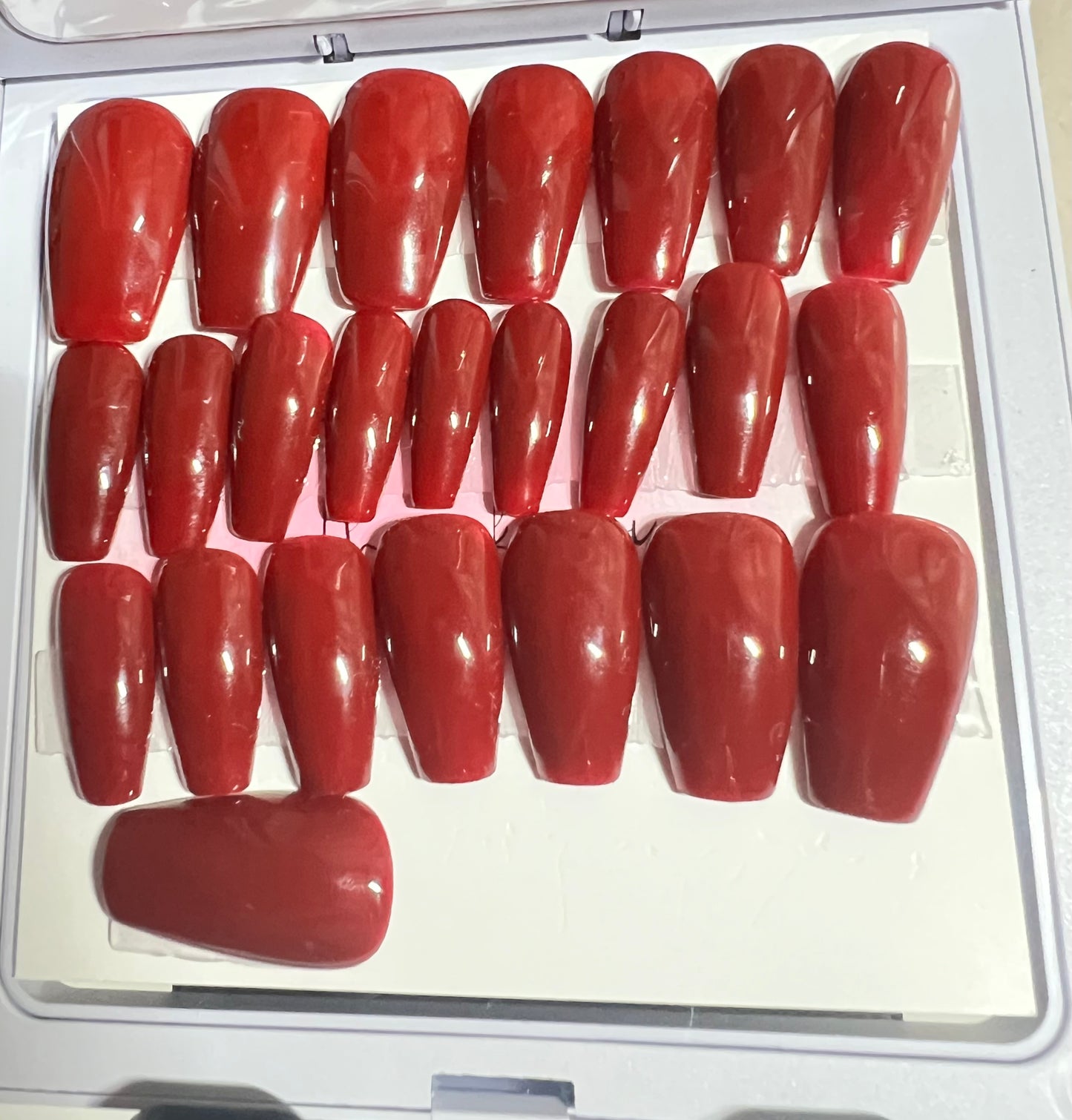 Set of 24 Medium length natural coffin press-on nails with a deep red brick gel polish and no stain top coat.