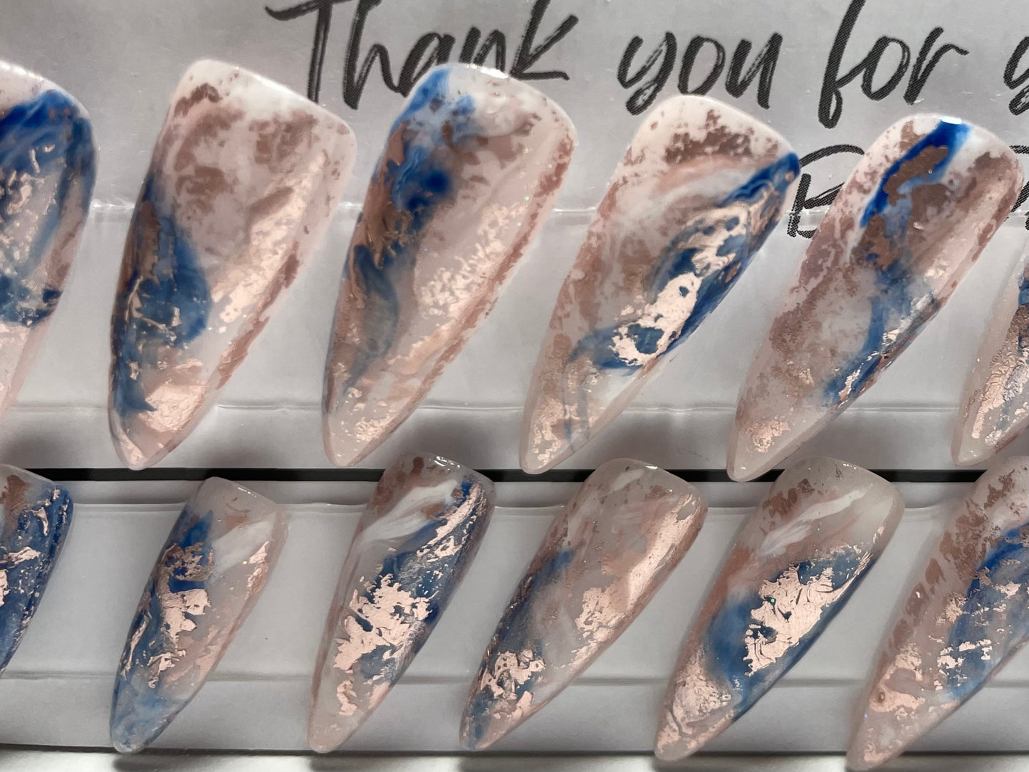 Professionally hand painted with acrylic and hard gel base. White and blue swishes and rose gold foil