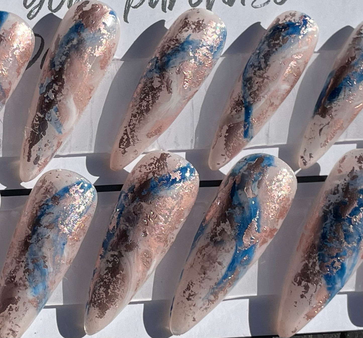 Set of 20 Long Stiletto shaped press-on nails with a layer of acrylic with hard gel over that. Gel polish; rose, white and blue marbled and hard gel top coat