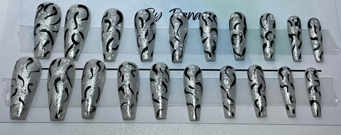 Professionally hand painted set of 20 nails with milky white gel polish and silver, black and white accents on each.nail. In person they are really pretty.