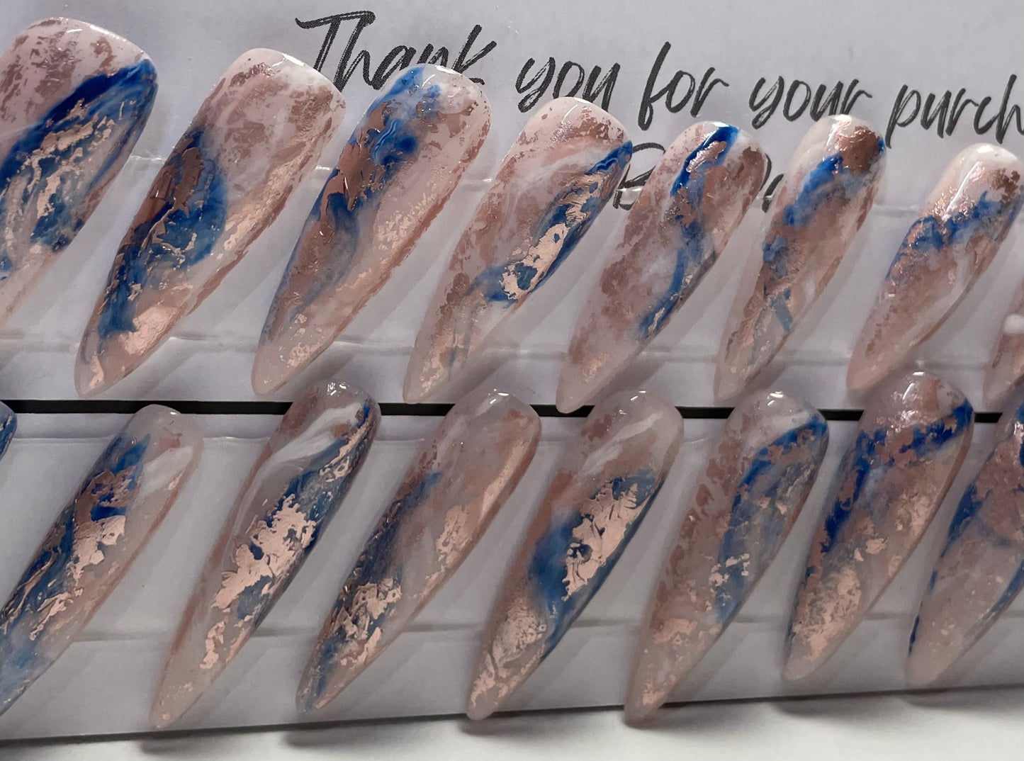 Set of 20 Long Stiletto shaped press-on nails with a layer of acrylic with hard gel over that. Gel polish; rose, white and blue marbled and hard gel top coat