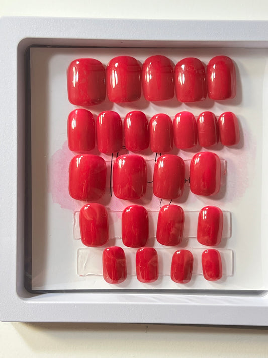 Set of 24 Short square press-on nails in a dark pink shade of gel polish.