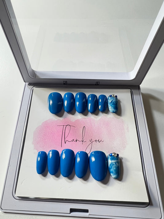 Size large, natural short round shape with 2 accent nails with blue and white marbling and stones by the cuticle.