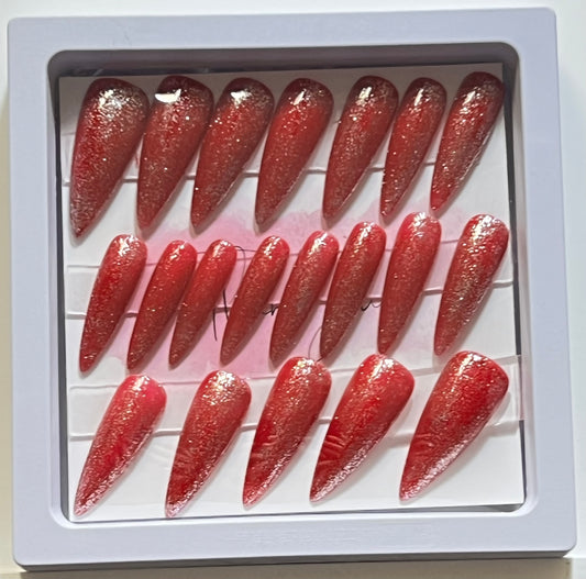 Set of 20 long stiletto nails with red gel polish and silver glitter over. No stain top coat.