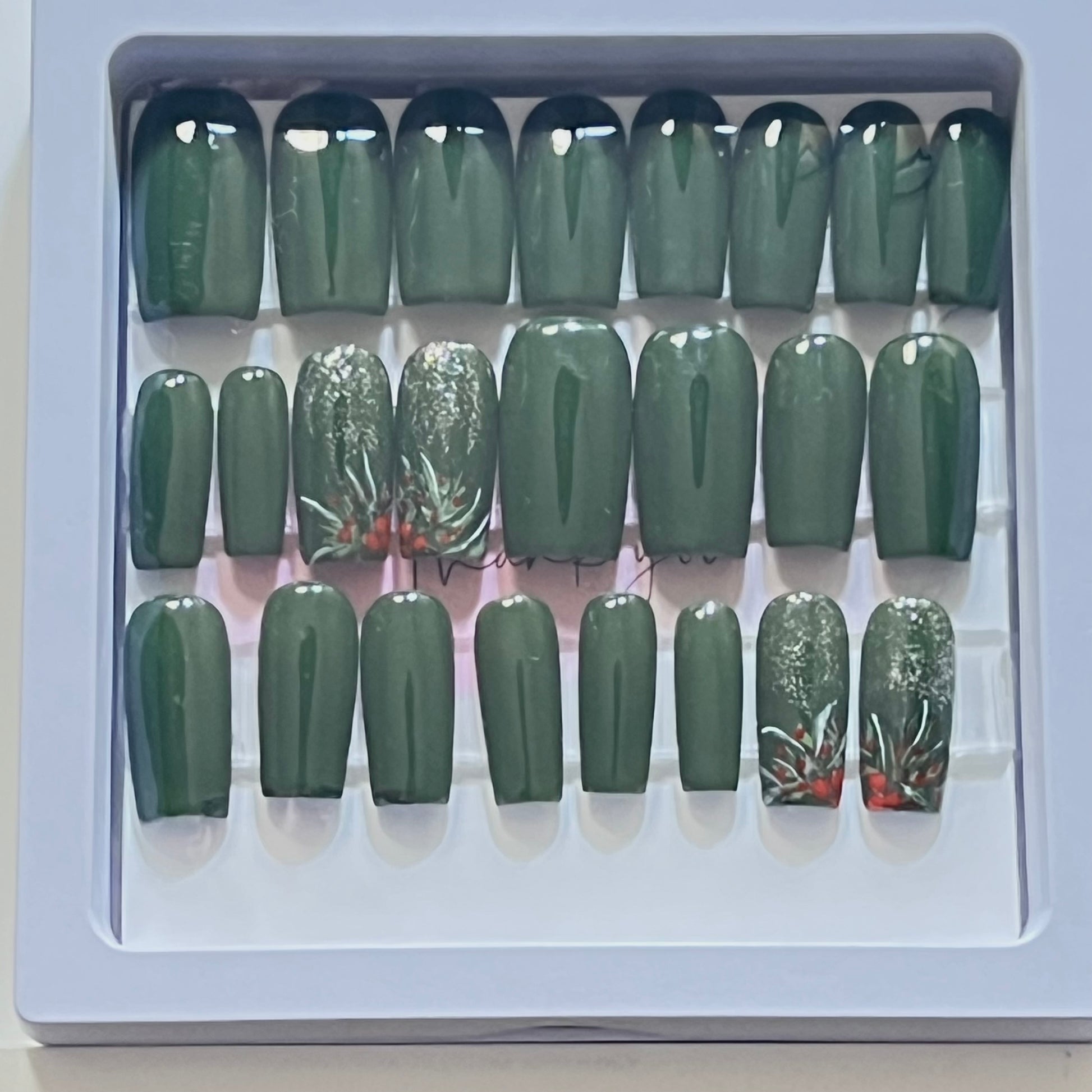 Set of 24 medium length square nails and 4 accent nails with hand painted holy with a sprinle of gold glitter. The other 20 nails are a solid dark green gel polish and not stain top coat.
