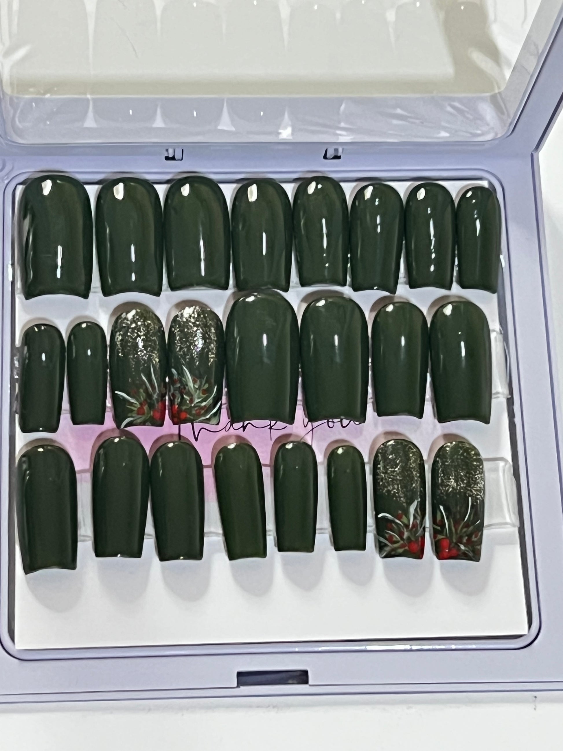 Set of 24 medium length square nails and 4 accent nails with hand painted holy with a sprinle of gold glitter. The other 20 nails are a solid dark green gel polish and not stain top coat.