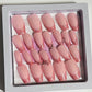 Set of 24 medium length coffin shaped nails with light pink/peach base and darker pink with glitter french tip. Included are 4 nails that are pierced with silver O rings and all are sealed with hard gel top coat.