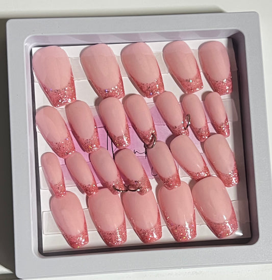 Set of 24 medium length coffin shaped nails with light pink/peach base and darker pink with glitter french tip. Included are 4 nails that are pierced with silver O rings and all are sealed with hard gel top coat.