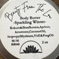 Body butter container with label on a wooden surface