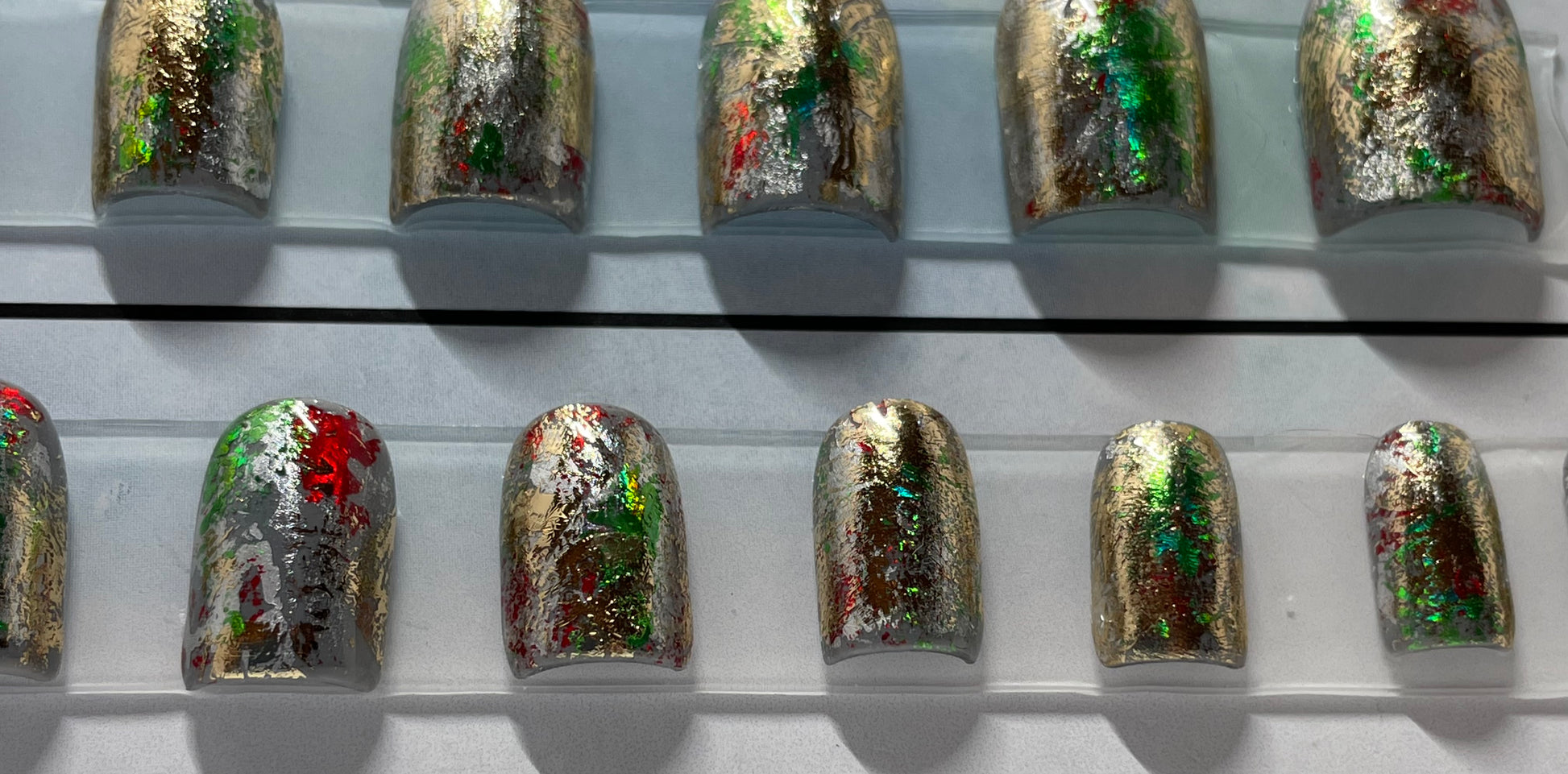 Fun holiday nails!! Hand painted by a professional nail tech. Silver, gold, red and green foil over all nails. 