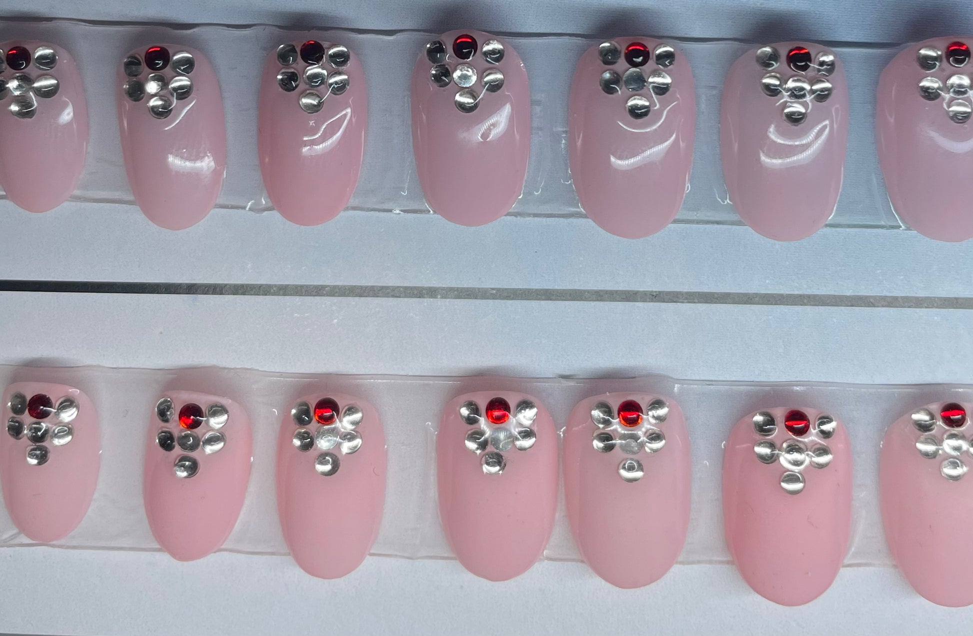 Hand Painted pink nails with The one red stone just adds that little pop of color!