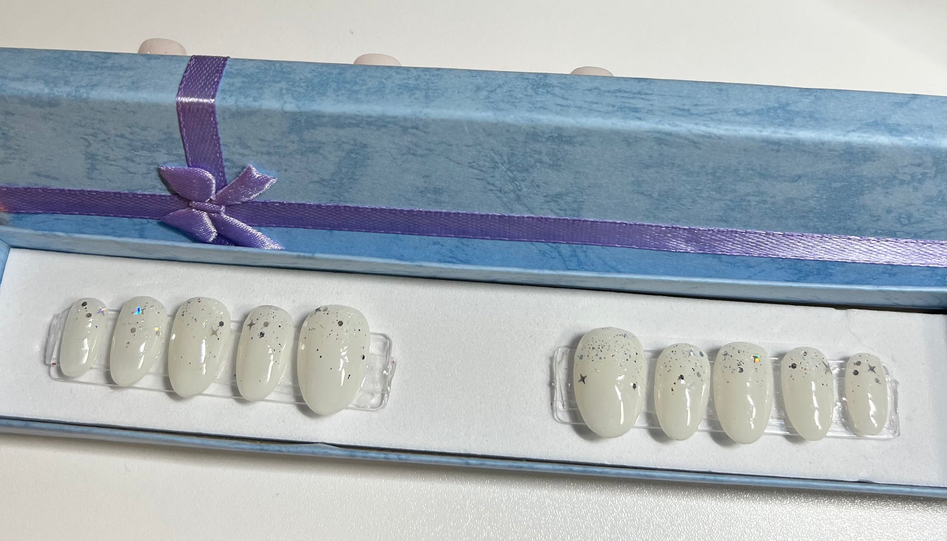 Size medium with soft white hand painted gel polish and silver glitter around the cuticle.
