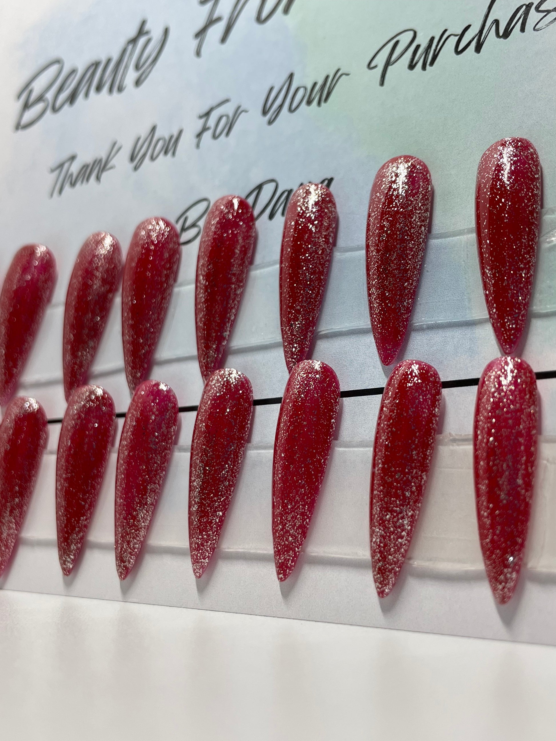 Professional hand painted nails with Pretty glitter gel over the red gel polish.